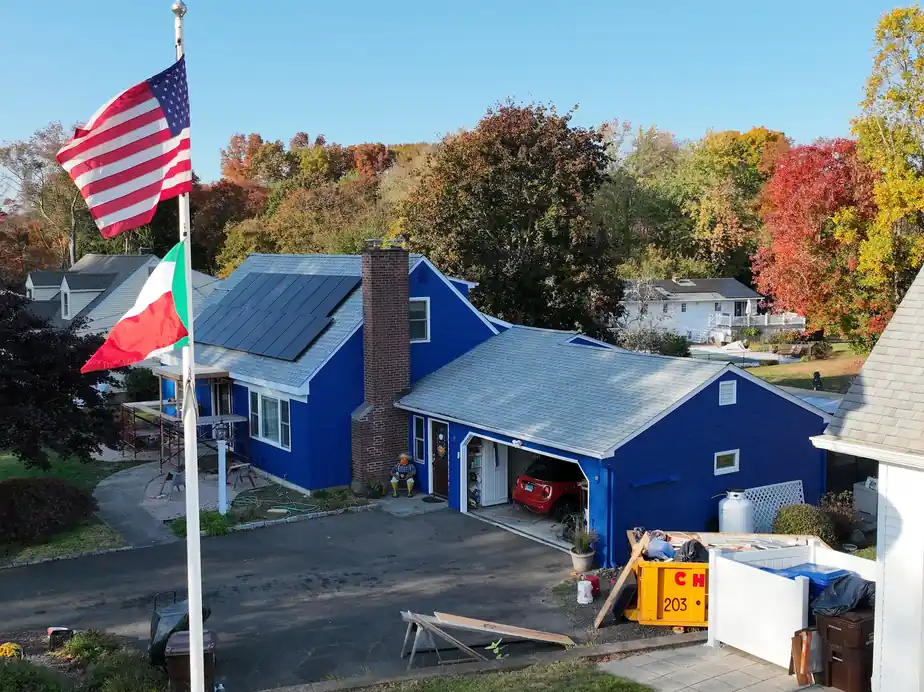 Aerial view of a blue Cape with two flags and autumn trees