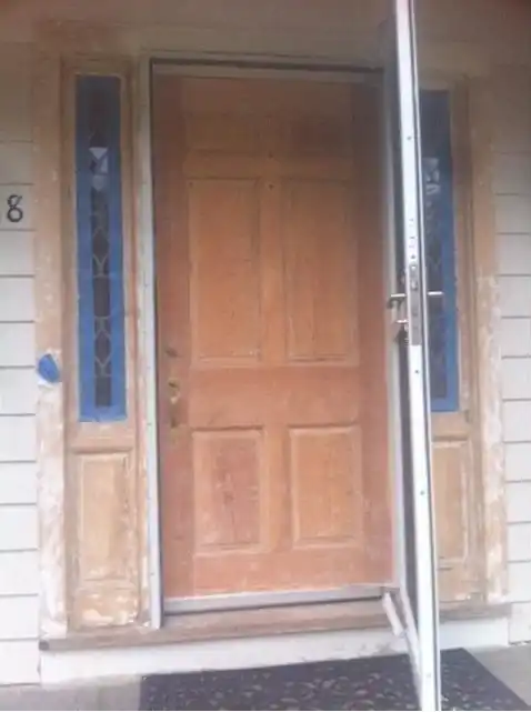 Worn, stained entry door with tired trim
